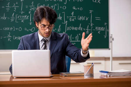 Young male math teacher in classroom