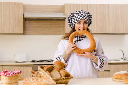Young female baker working in kitchenの写真素材
