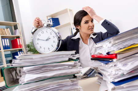 Female employee with too much work in the officeの写真素材