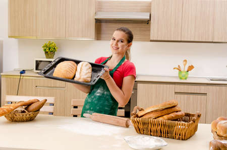 Young female baker working in kitchen