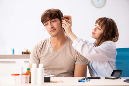 Patient with hearing problem visiting doctor otorhinolaryngologiの写真素材