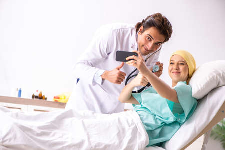 Young handsome doctor visiting female oncology patient