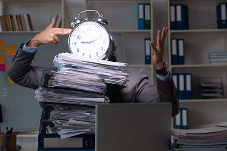 Young male employee working late at officeの写真素材