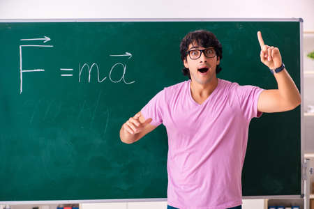 Young male physic standing in front of the green board