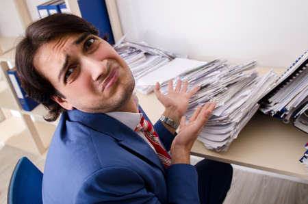 Young businessman employee unhappy with excessive workの写真素材