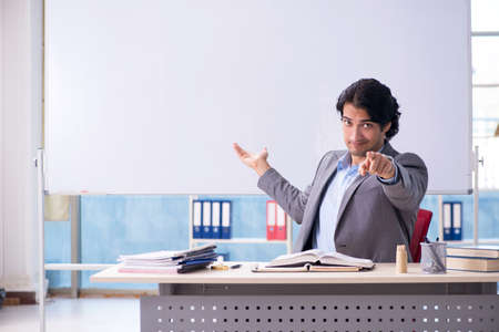 Young handsome teacher in front of whiteboardの写真素材