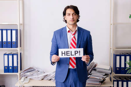 Young businessman employee unhappy with excessive workの写真素材