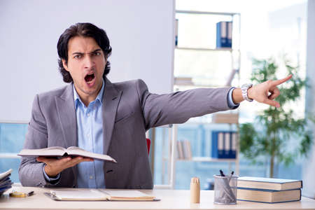Young handsome teacher in front of whiteboardの写真素材