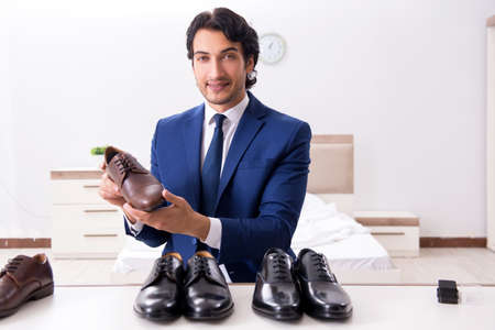 Young handsome businessman choosing shoes at homeの写真素材