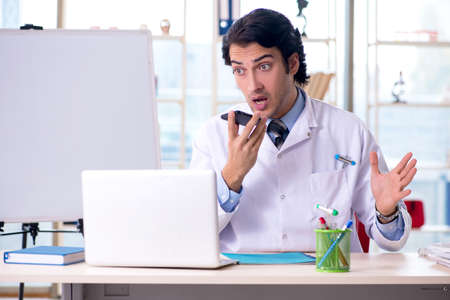 Young handsome doctor in front of whiteboardの写真素材