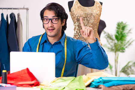 Young male tailor working at workshopの写真素材