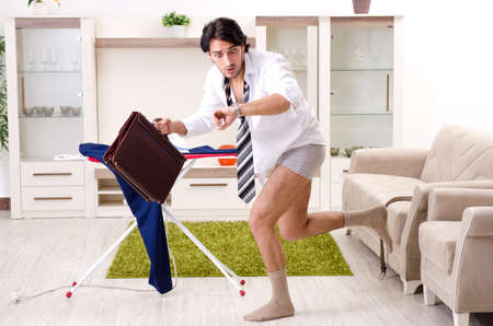 Young man ironing in the bedroomの写真素材