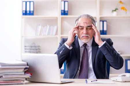 White bearded old businessman employee unhappy with excessive workの写真素材