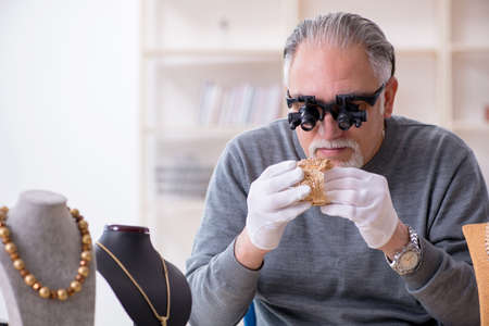 White bearded old jeweler at workshopの写真素材