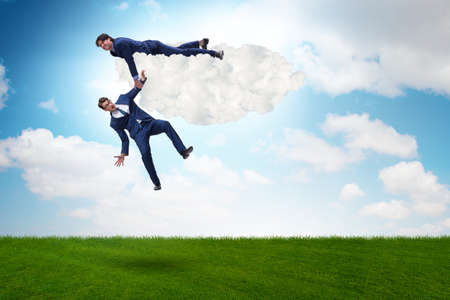 Businessman offering helping hand to falling colleague