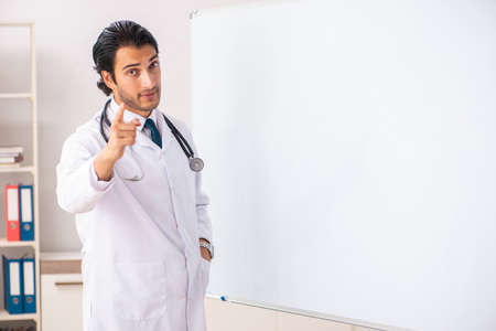 Young doctor in front of whiteboardの写真素材