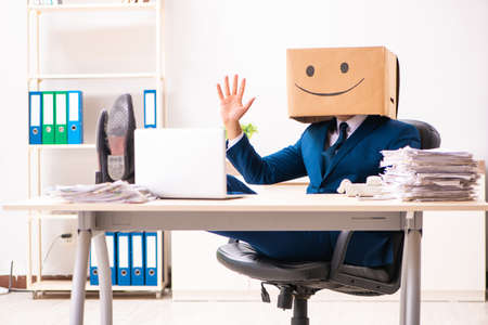 Happy man employee with box instead of his headの写真素材