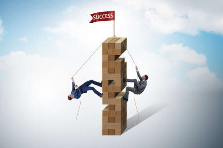 Competition concept with two businessmen climbing towerの写真素材