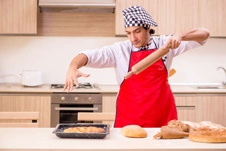 Young male baker working in kitchen