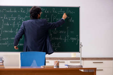 Young male math teacher in classroom