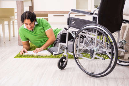 Young handsome man in wheelchair at home
