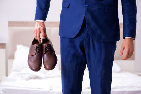 Young handsome businessman choosing shoes at homeの写真素材