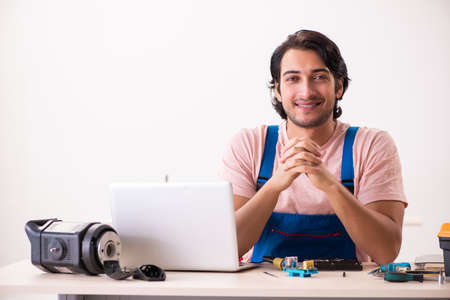 Young male contractor repairing computerの写真素材