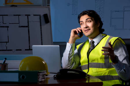 Young construction architect working on project at night
