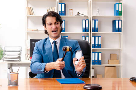 Young handsome judge sitting in courtroomの写真素材