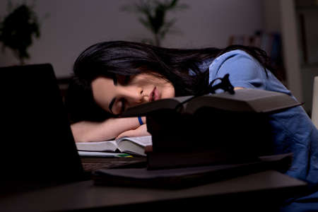 Young female student preparing for exams at night timeの写真素材