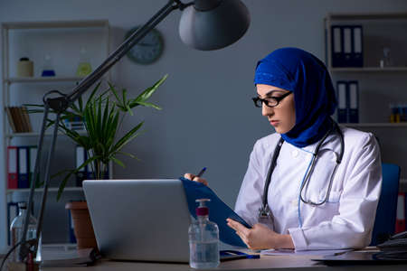 Arab female doctor working in the clinic at nightの写真素材