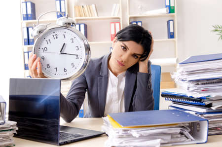 Middle aged businesslady unhappy with excessive workの写真素材