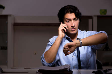 Young handsome employee and too much work in the officeの写真素材