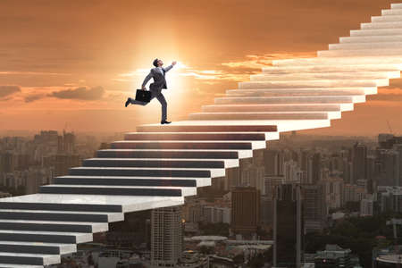 Businessman climbing career ladder over cityの写真素材
