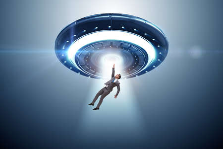 Flying saucer abducting young businessmanの写真素材