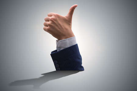 Male hand with thumbs up approval gestureの写真素材
