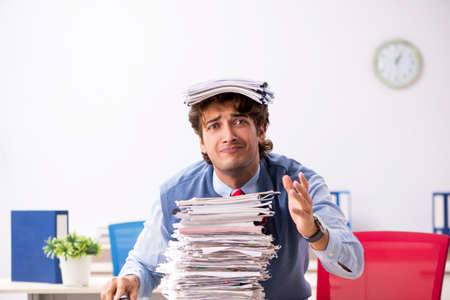 Young handsome employee unhappy with excessive work