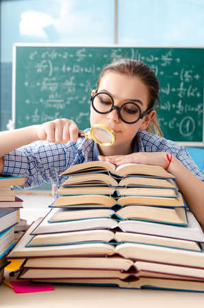 Female student with many books sitting in the classroomの写真素材