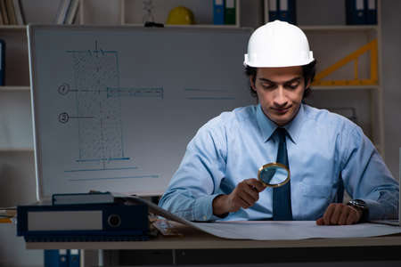 Young male architect working night at office
