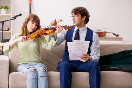 Young woman during music lesson with male teacherの写真素材