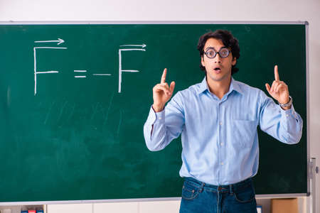 Young male physic standing in front of the green board