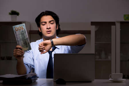 Young handsome employee and too much work in the officeの写真素材