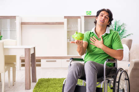 Young handsome man in wheelchair at homeの写真素材