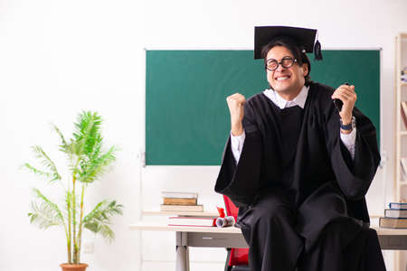 Graduate student in front of green boardの写真素材