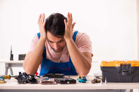 Young male contractor repairing computer