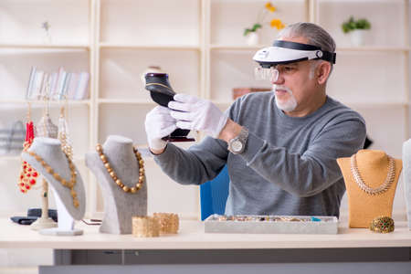 White bearded old jeweler at workshop