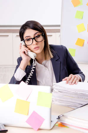 Young female employee in conflicting priorities conceptの写真素材