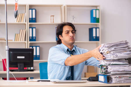 Young male employee in blood transfusion conceptの写真素材