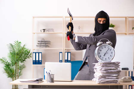 Male gangster stealing information from the officeの写真素材