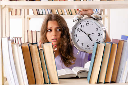 Young female student preparing for exams at libraryの写真素材